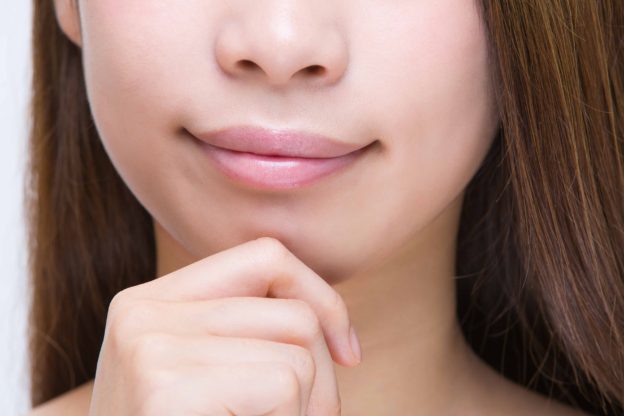 顎元に手を置いている女性
