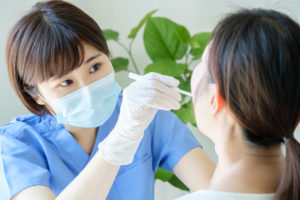 患者の口内を診察している歯科医師