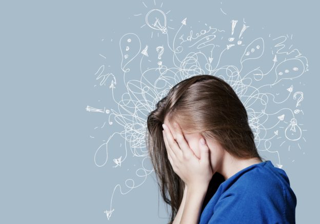 青い服を着た髪の長い女性が顔を覆っている
