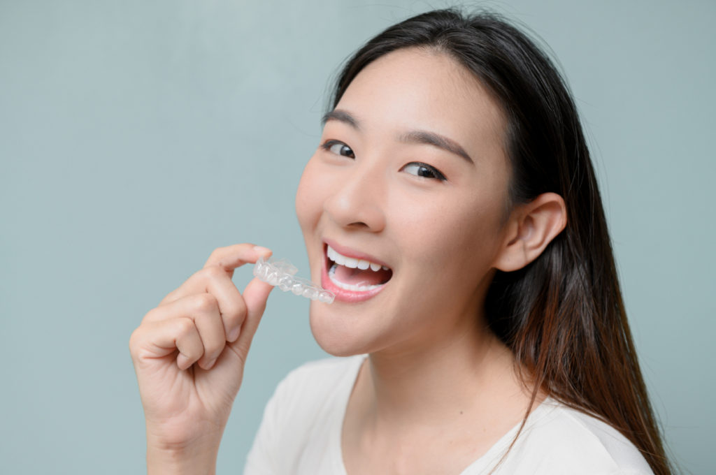 マウスピースをもって笑顔の女性