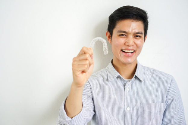 マウスピースを手に取り笑顔の男性