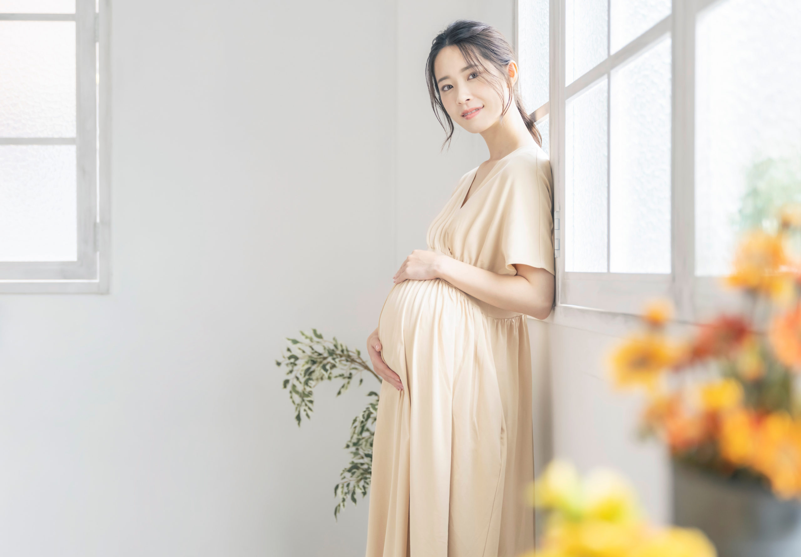 妊娠して膨らんだお腹を支える女性