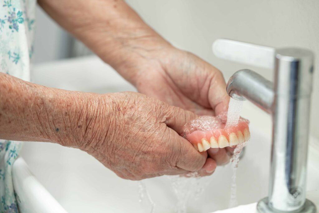 入れ歯を水で洗っている